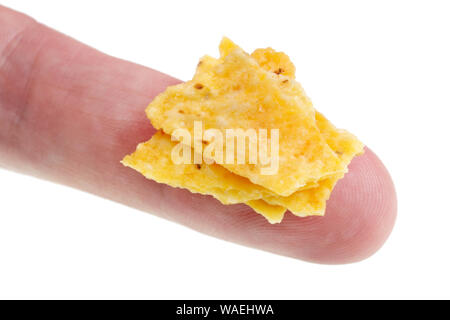 In the future we will eat this concept - small ugly bad  potato chips  crumbs  on finger. Isolated on white studio macro Stock Photo