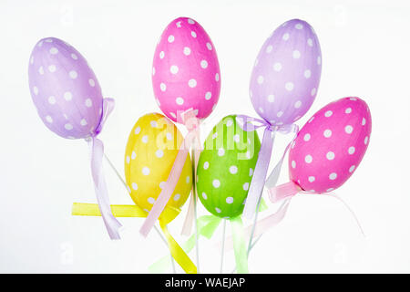 Traditional  rustic style  homemade  paper  Easters eggs  on sticks  on white bacjground Stock Photo