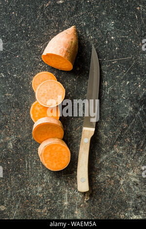 The sweet potatoes on old kitchen table. Stock Photo