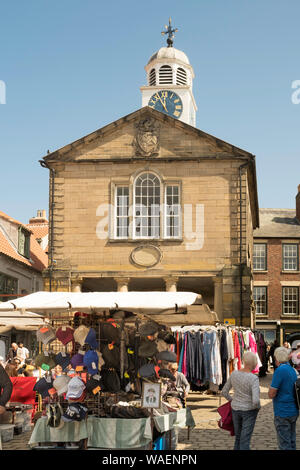 People shopping in Whitby market place and the Old Town Hall, North Yorkshire, England, UK Stock Photo
