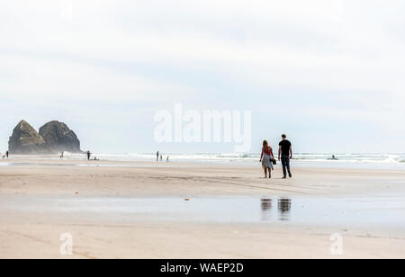 Lovely Young couple are walking along the shore of the Northwest Pacific Ocean and breathing healthy fresh sea air to strengthen immunity and strength Stock Photo