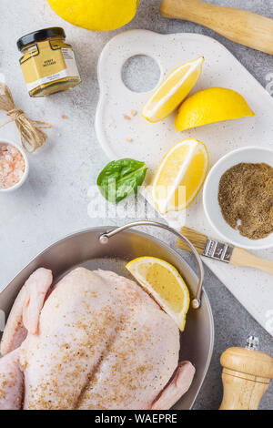 Preparing stuffed whole turkey or chicken for a festive celebration dinner. Raw poultry with herbs, spices, lemon and honey mustard. Stock Photo