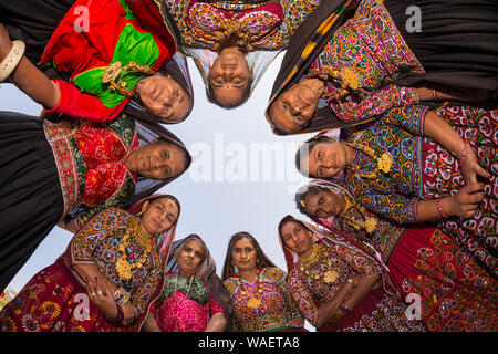Group of Ahir Women in traditional colorful cloth looking down with head in circle, Great Rann of Kutch Desert, Gujarat, India Stock Photo