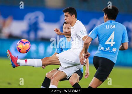 Colombian football player Giovanni Moreno, center, of Shanghai Greenland Shenhua passes the ball against Dalian Yifang in the semifinal match during the 2019 Chinese Football Association (CFA) Super Cup in Dalian city, northeast China's Liaoning province, 19 August 2019. Shanghai Greenland Shenhua defeated Dalian Yifang 3-2. Stock Photo