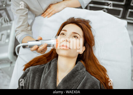 Female cosmetologist making oxygen mesotherapy to a woman at the luxury beauty salon. Concept of a professional facial treatment Stock Photo