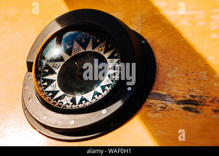 Ship black compass on wood background. Stock Photo