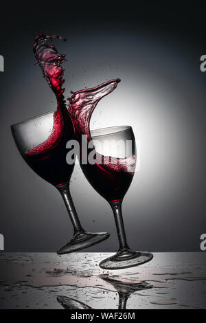 Red Wine in glasses splashing as they clink together. Stock Photo
