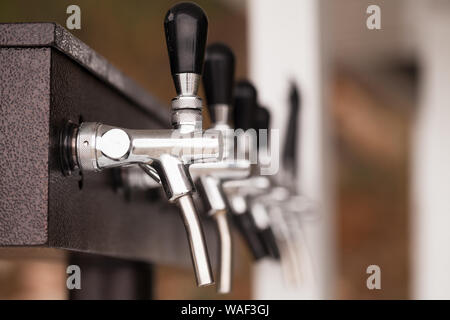 Modern beer taps in a row, close up photo with soft selective focus Stock Photo