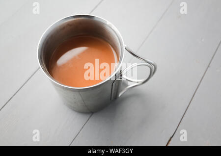 Thermos and Mug with Hot Drink Standing on Wet Wooden Table after