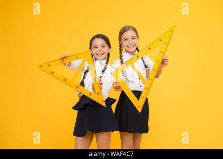 Pupil school girls big rulers. School knowledge. Explore world with math. Mathematical theory combining algebraic and geometric methods. Discover mathematics patterns. School students study geometry. Stock Photo