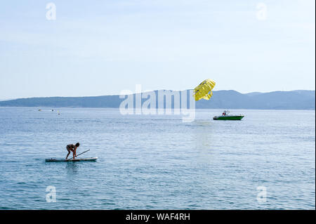 Parasailing and balance act on a paddleboard in the Adriatic sea on the Makarska riviera Stock Photo
