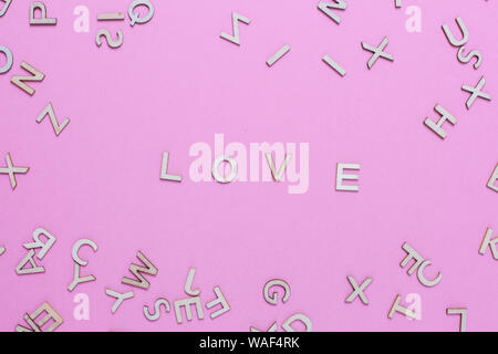 Wooden ABC alphabet letters on pink background.Love word written with wooden letters Stock Photo