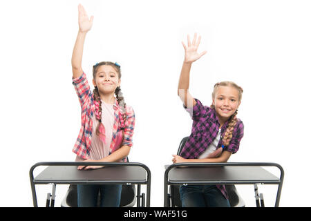 Enjoy process of studying. Little girls school friends study together. Raise hands to answer. Students classmates sit desk. Back to school. Private school concept. Elementary school education. Stock Photo