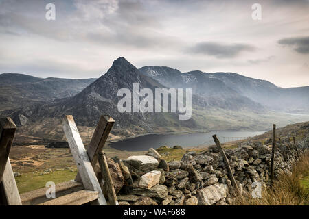 Moody scenic view of Mount Tryfan peak, (welsh Glyderau Mountain Range) & Llyn Ogwen below, Snowdonia National Park, UK, in early evening mist. Stock Photo