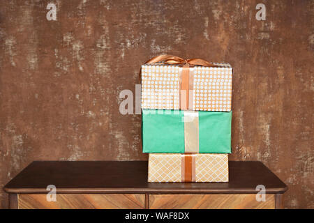 Stack of handcraft gift boxes on wooden board with a natural textured brown background Stock Photo