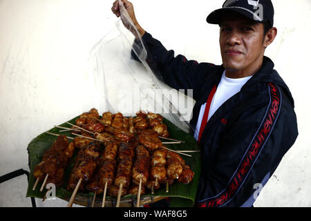 ANTIPOLO CITY, PHILIPPINES – AUGUST 16, 2019: Street vendor showing deep fried sweet snacks like Turon or sweet banana, Carioca or rice flour balls an Stock Photo