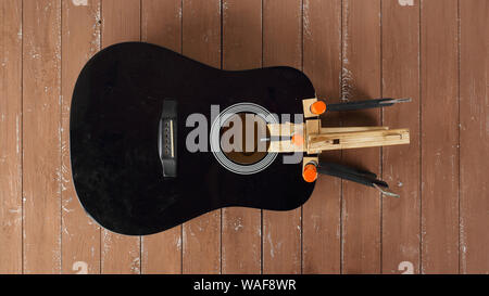 Guitar repair and service - Repair clamping broken sound board acoustic guitar top view wooden background Stock Photo