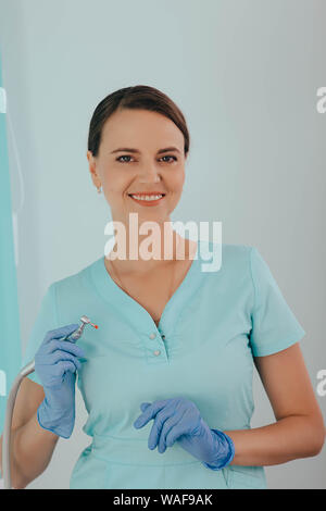 portrait positive beautiful female dentist with dental drill at dental clinic Stock Photo