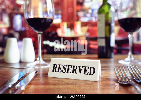 Restaurant reserved table sign with places setting and wine glasses ready for a party Stock Photo