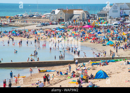 Lyme Regis, Dorset, UK. 20th Aug, 2019. UK Weather: Holidaymakers and beachgoers pack the picturesque beach at the seaside resort of Lyme Regis on a hot and sunny afternoon. The baking hot weather is set to continue over towards the bank holiday when crowds of visitors are set to flock to the south coast as the school summer holiday continues. Credit: Celia McMahon/Alamy Live News Stock Photo