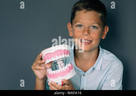 Cute boy showing model of teeth. Funny advertising child teeth treatment Stock Photo