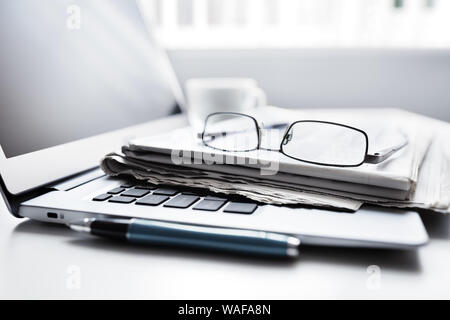 Newspaper on laptop computer, internet and electronic online news Stock Photo