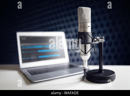Podcast microphone and laptop computer on desk in recording studio Stock Photo