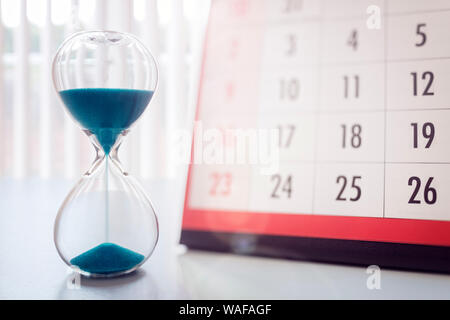 Hour glass and calendar concept for time slipping away for important appointment date, schedule and deadline Stock Photo