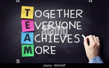 Team - together everyone achieves more written on blackboard Stock Photo