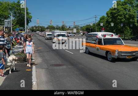 Long Island, NY - Circa 2019: Ambulance fleet drive by crowd watching Memorial Day parade through streets of small town America during summer holiday Stock Photo