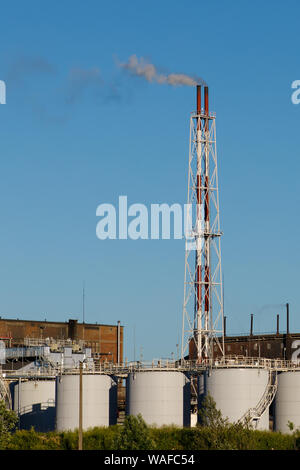 Smoke stack billowing smoke from a coal plant Smoke from the chimney against a clear blue sky. Stock Photo