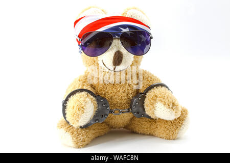 Plush teddy bear with handcuffs on white background Stock Photo