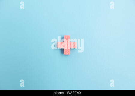 Top view of Pink Plus sign on blue color background. Stock Photo