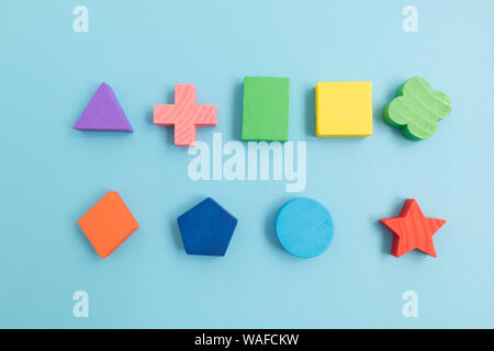 Top view Colorful Wooden building blocks with different shapes for developing and entertainment of Children on blue background Stock Photo