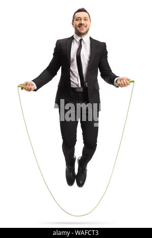 Full length portrait of a young man in a suit skipping a rope and smiling isolated on white background Stock Photo