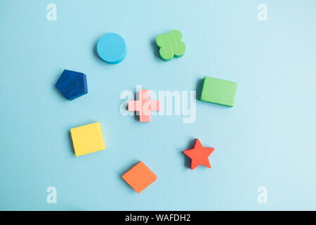 Top view Colorful Wooden building blocks with different shapes for developing and entertainment of Children on blue background Stock Photo