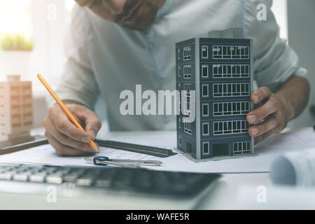 architect working with new apartment building scale model in office Stock Photo