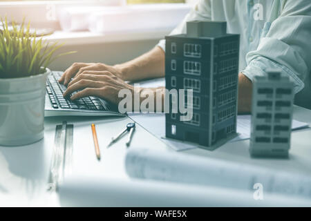 architect working on computer in office typing on keyboard Stock Photo