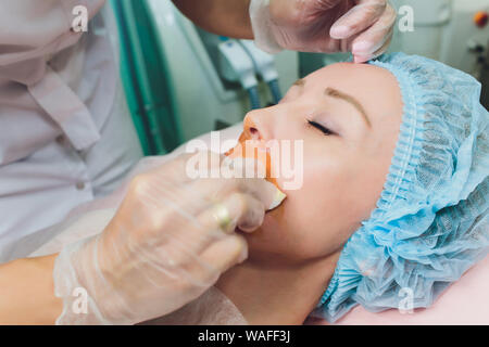 Close up of a hands threading beautiful womans upper lip. Stock Photo