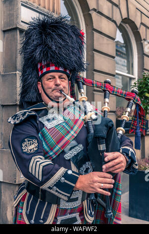 Close up head and shoulders of a Scottish bagpiper playing pipes in full uniform Edinburgh, Scotland Stock Photo