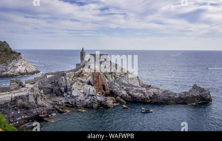 PORTOVENERE, LIGURIA, ITALY - AUGUST 17, 2019: Tourists around Saint Peter's Church aka Chiesa di San Pietro, in Portovenere. Wide view. Stock Photo