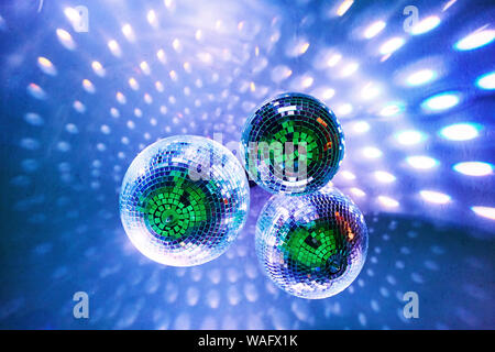 Disco balls with bright rays and highlights at the night disco in the club. Background image Stock Photo