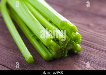 Celery closeup on wooden background. Stems of fresh organic green celery closeup. Healthy eating, diet concept Stock Photo