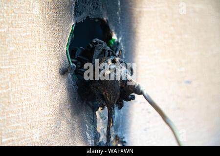 Burnt power outlet. Melted-off and burned plastic socket of power supply. Stock Photo
