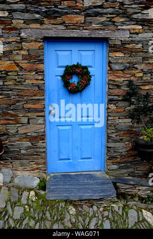 Rustic hand-hewn wood door set into a stone wall built from schist in Piodão, made of shale rocks stack, one of Portugal's schist villages in the Alde Stock Photo