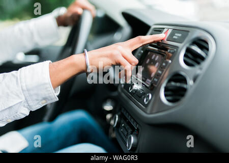 Presses the stop. Young indian man hitting car emergency red light button in the cars. Stock Photo