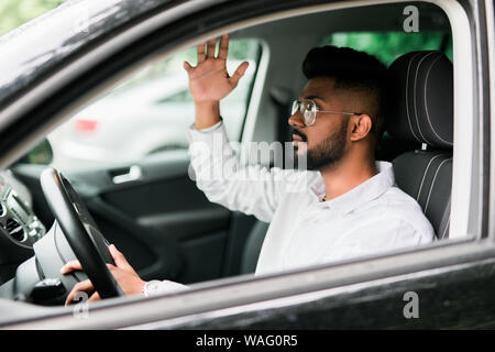 Rear view of young man driving a car and looks angry, shouting inside the car Stock Photo