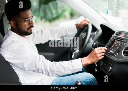 Man is going to drive, looking for some nice music Stock Photo