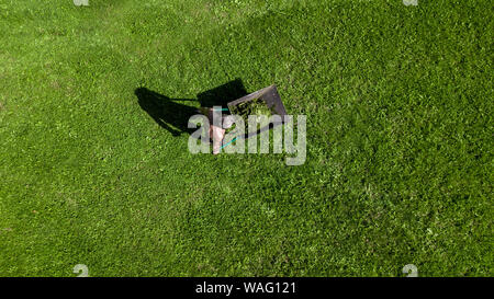 man pulls a wheelbarrow with garbage top view Stock Photo