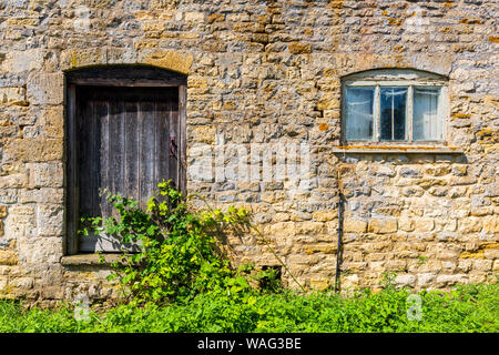 A Cotswold barn window and wooden door, England Stock Photo